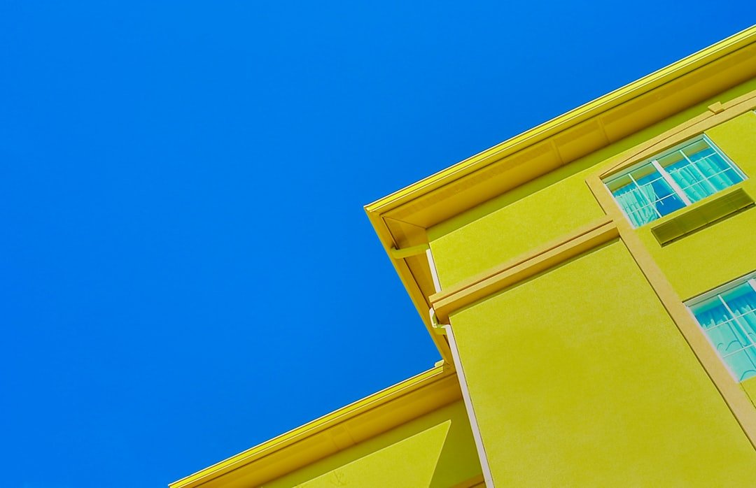 a yellow building with a blue sky in the background
