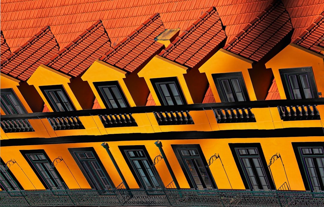 a yellow building with black windows and balconies