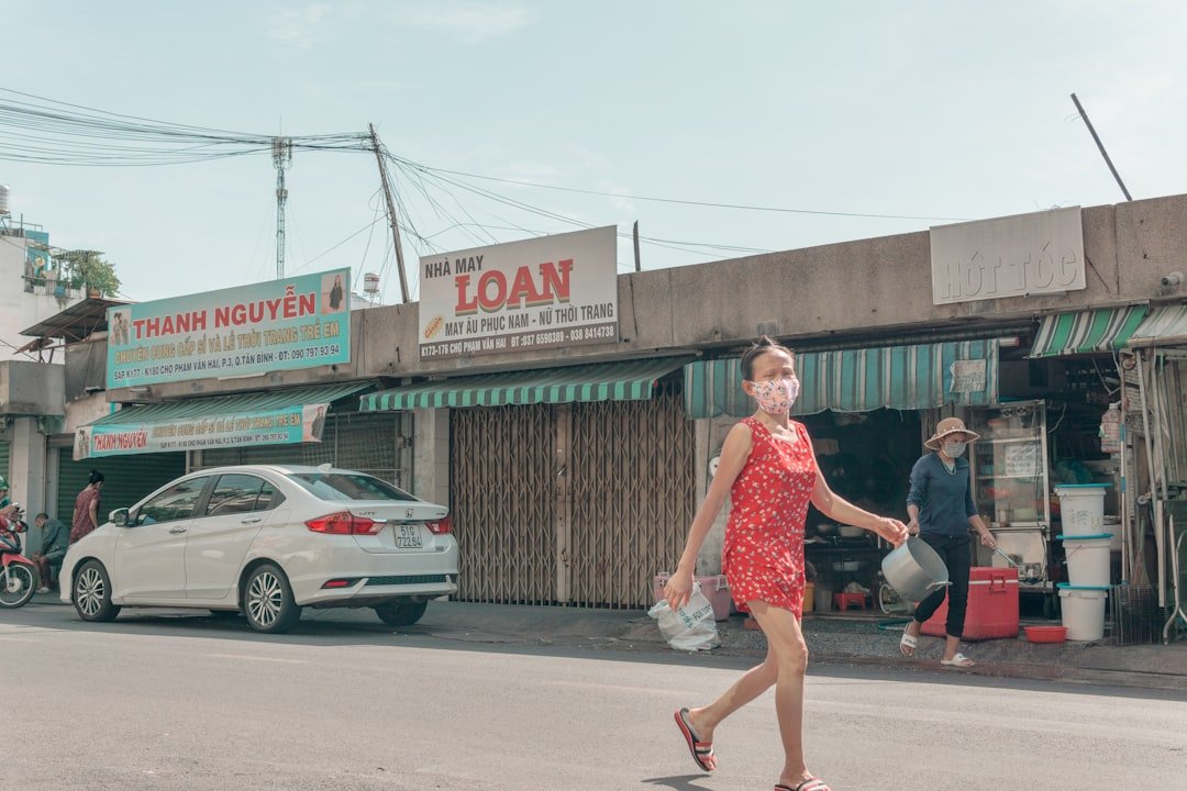a woman in a red dress crossing a street