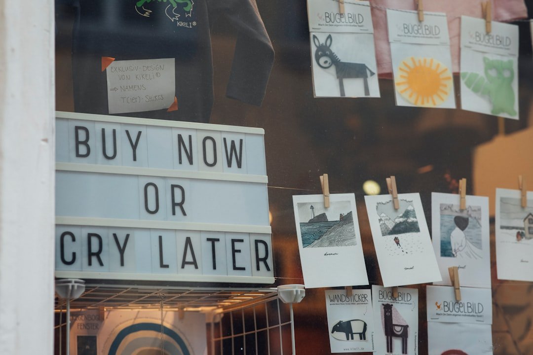 a store window with a sign that says buy now or cry later