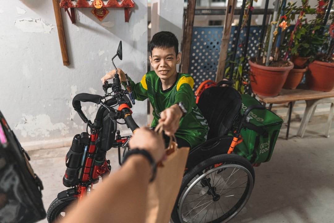 a boy in a green shirt sitting in a wheel chair