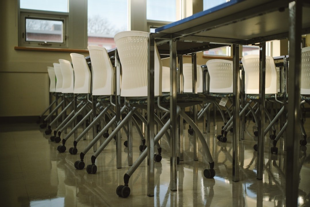 Empty classroom with chairs under tables.
