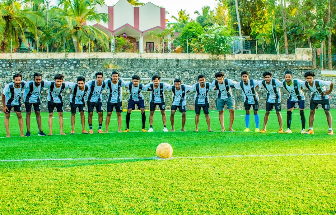 soccer players on green grass field during daytime